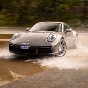 Grey Porsche driving through shallow water