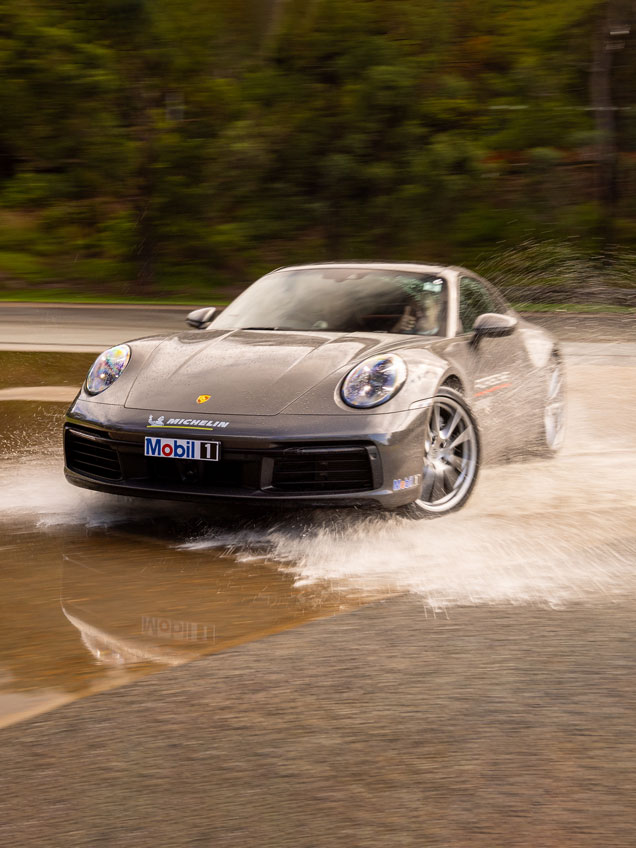 Grey Porsche driving through shallow water